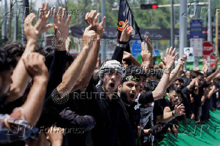 Shi'ite mourners raise their hands and shout slogans during during a Muharram procession ahead of Ashura in Srinagar