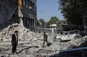 People gather near a damaged site, in Damascus