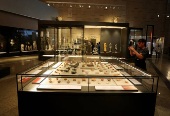 A visitor takes a photo of museum exhibits displayed at the Grand Egyptian Museum