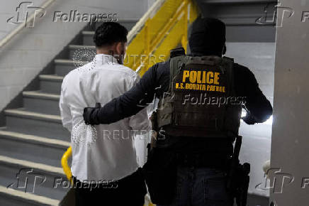 A migrant is detained by federal immigration officers at U.S. immigration court