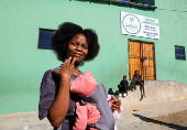Athenkosi Sobuza stands with her two-months-old baby, Liselihle, outside the Fellowship Baptist Church, where U.S. pastor Josh Sullivan was kidnapped, in Gqeberha