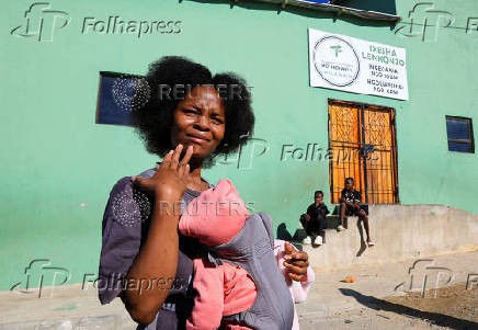 Athenkosi Sobuza stands with her two-months-old baby, Liselihle, outside the Fellowship Baptist Church, where U.S. pastor Josh Sullivan was kidnapped, in Gqeberha
