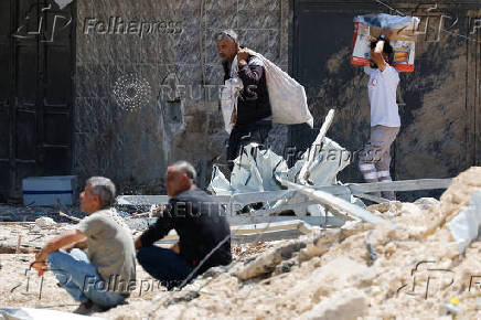 Palestinians carry their belongings after Israel's decision to demolish their homes in Nur Shams camp
