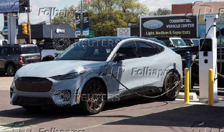 A 2025 Ford Mustang Mach_E sits at a charging station, at a dealership in Dearborn, Michigan