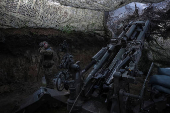 Servicemen fire a howitzer towards Russian troops at position on front line in Donetsk region