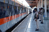Security force personnel stand guard as India's high-speed train 