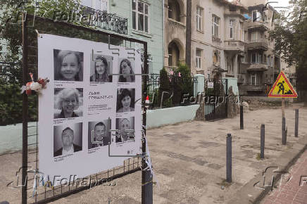 Un cartel muestra los rostros de los cuatro miembros de la familia Basilevich fallecidos en la guerra de Ucrania