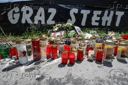 Flowers and candles are seen in front of the fences of the school in Graz