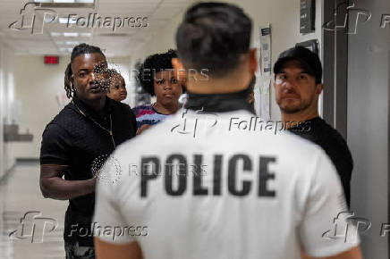 A migrant is detained by federal immigration officers at U.S. immigration court