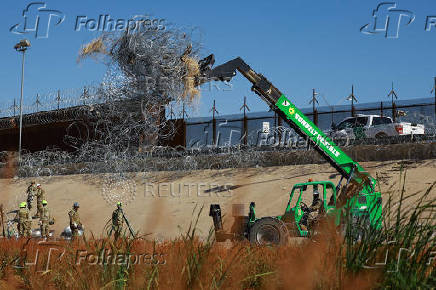 Members of the U.S. military replace concertina wire at on the U.S.-Mexico border, as seen from Ciudad Juarez