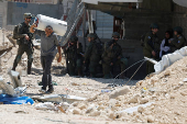Palestinians carry their belongings after Israel's decision to demolish their homes in Nur Shams camp