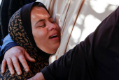 People gather near the bodies of Palestinians killed in Israeli strikes, in Khan Younis