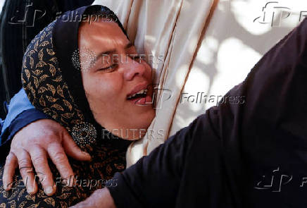 People gather near the bodies of Palestinians killed in Israeli strikes, in Khan Younis