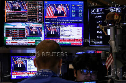 Traders work, as screens broadcast a news conference by U.S. Federal Reserve Chair Jerome Powell following the Fed rate announcement, on the floor of the NYSE in New York
