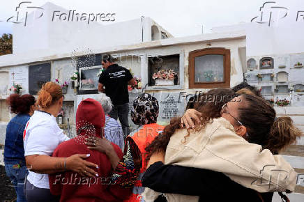 People stand with the mother of 12-year-old migrant girl Fatoumatta Banaro during her burial, after the wooden boat she was traveling on sank in the port of La Restinga