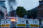 Armed police in riot gear stand guard during a second night of riots, in Ballymena