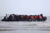 FILE PHOTO: Migrant dinghy heads off the French coast to cross the English channel