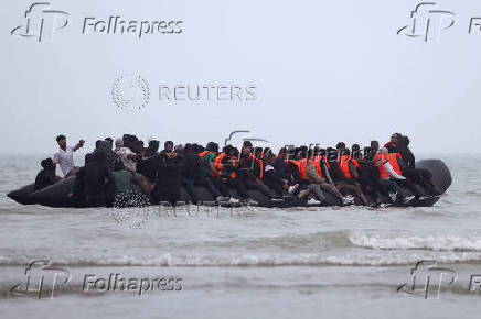FILE PHOTO: Migrant dinghy heads off the French coast to cross the English channel