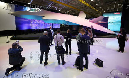 Journalists stand next to a concept model of the new GCAP (Global Combat Air Programme) 6th generation military jet at the BAE Systems Warton factory in Warton, Britain