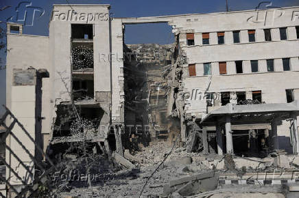 People gather near a damaged site, in Damascus