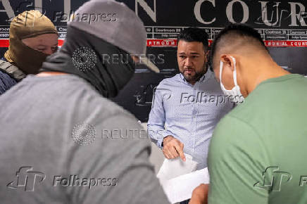 A migrant is detained by federal immigration officers at U.S. immigration court