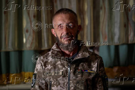 Ukrainian war veteran and IDP from village near Enerhodar, pose for photo in his temporary home, in Zaporizhzhia