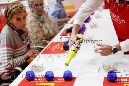 Women get ready to sample Spanish Sierra Magina olive oil amid the newly imposed U.S. tariffs at the 38th Gourmets Fair in Madrid