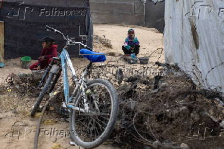 Displaced Palestinians collect donated food in Khan Yunis, southern Gaza