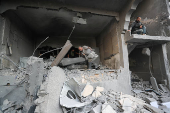 Palestinians inspect the damage at the site of an Israeli strike on a house, in Jabalia