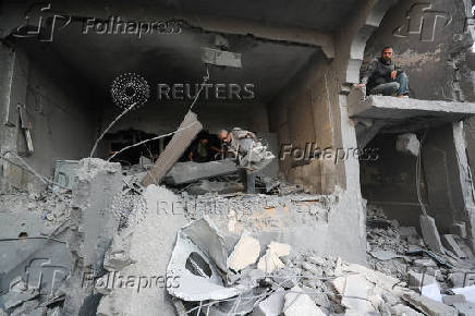 Palestinians inspect the damage at the site of an Israeli strike on a house, in Jabalia