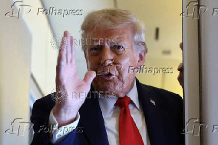 Trump speaks aboard Air Force One on his return from a state visit in Britain