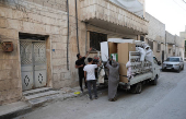 Syrian returnee Ahmed Al-hadid, and his family members unload belongings from a truck, in Aleppo's countryside