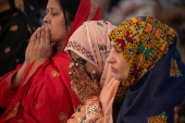Woman raises henna adorned hands in devotion after Eid al-Adha prayer in Lahore