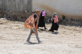 Palestinians carry their belongings after Israel's decision to demolish their homes in Nur Shams camp
