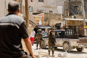 Palestinians carry their belongings after Israel's decision to demolish their homes in Nur Shams camp