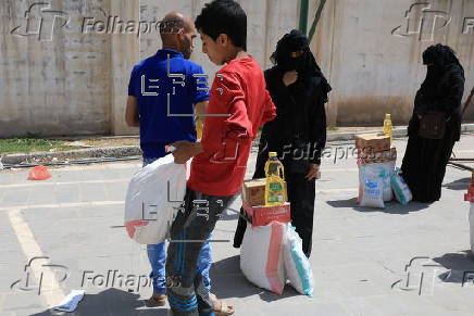 Yemenis receive food aid in Sana'a, distributed by Mona Relief agency