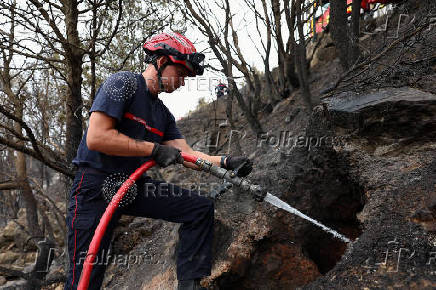 Firefighters work in wildfire-affected areas in southern France