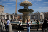 People take pictures with phones at St. Peter's Square in the Vatican