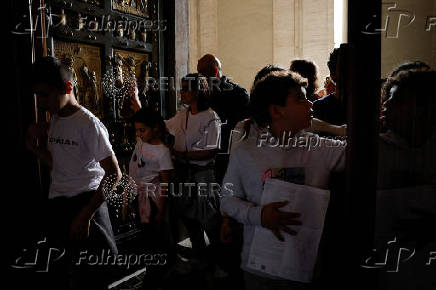 Faithful touch the Holy Door in St. Peter's Basilica at the Vatican