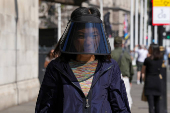 A woman wears a sun shield over her face in London