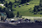 A few remaining houses are seen after a massive rock and ice slide covered most of the village of Blatten