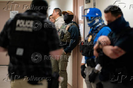A migrant is detained by federal immigration officers at U.S. immigration court
