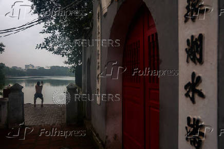 A man exercises next to Hoan Kiem Lake in Hanoi
