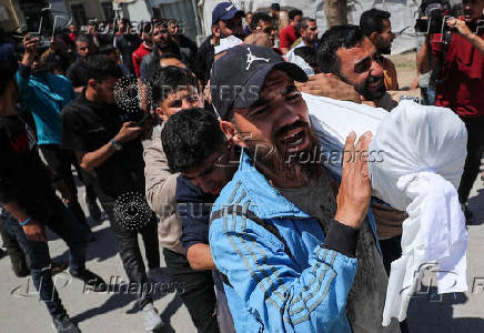 Mourners carry the body of a Palestinian killed in Israeli strikes, at Al-Ahli Arab Baptist hospital, in Gaza City