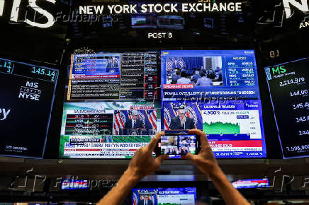 A screen displays a press conference by U.S. Federal Reserve Chair Jerome Powell following the Fed rate announcement, on the floor of the NYSE in New York