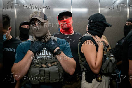 A migrant is detained by federal immigration officers at U.S. immigration court
