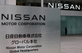 FILE PHOTO: A man stands in front of the global headquarters of Nissan Motor while its annual shareholder meeting is being held in Yokohama