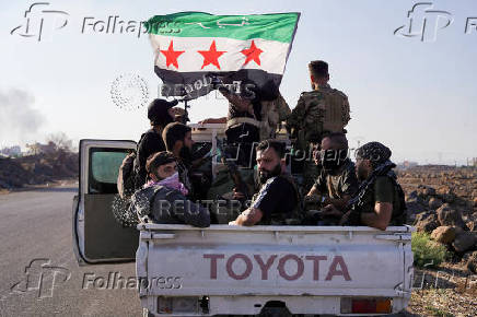 Members of Syrian security forces sit together at a back of a truck after Syrian troops entered the predominantly Druze city of Sweida