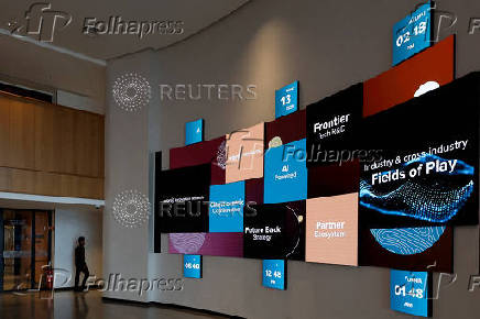 A man walks past screens in the innovation lab inside the premises of Wipro in Bengaluru