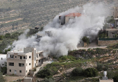 Smoke rises after the Israeli army blew up the house of a Palestinian assailant in Deir Ibzi town, near Ramallah